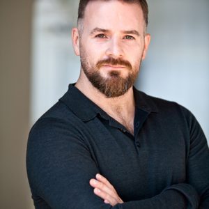 A persons headshot with them in the centre towards camera