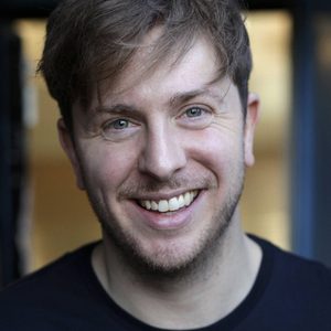 A persons headshot with them in the centre towards camera