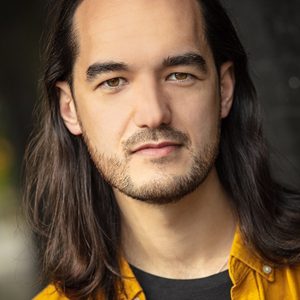 A persons headshot with them in the centre towards camera