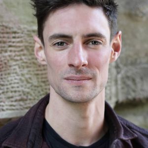 A persons headshot with them in the centre towards camera