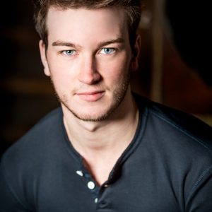 A persons headshot with them in the centre towards camera