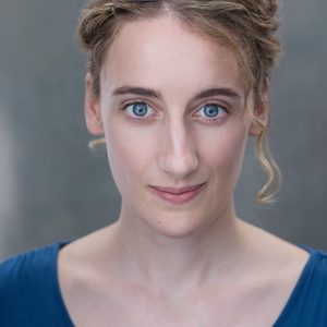 A persons headshot with them in the centre towards camera