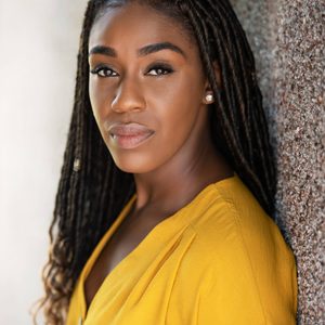 A persons headshot with them in the centre towards camera