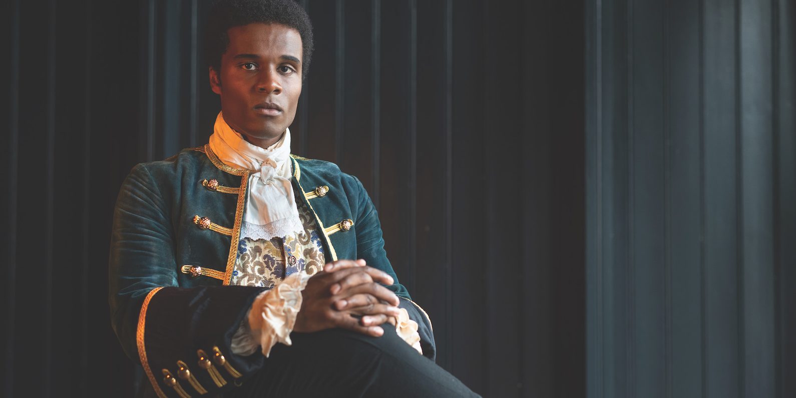 A man sat in historical dress.