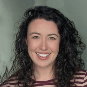 Headshot of Rachael McAllister - she is smiling and had long brown curly hair.