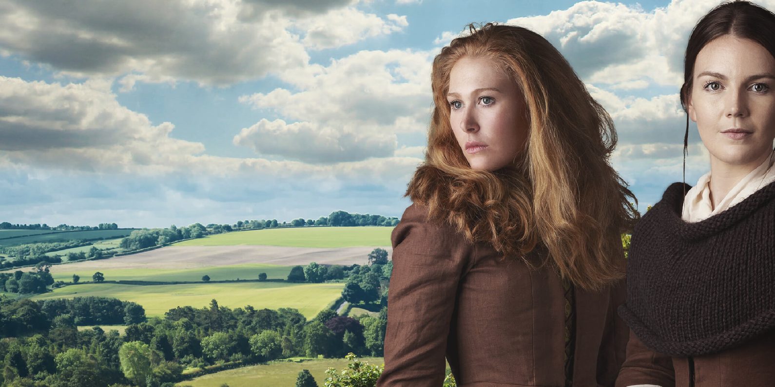 Two women standing in front of rolling green fields