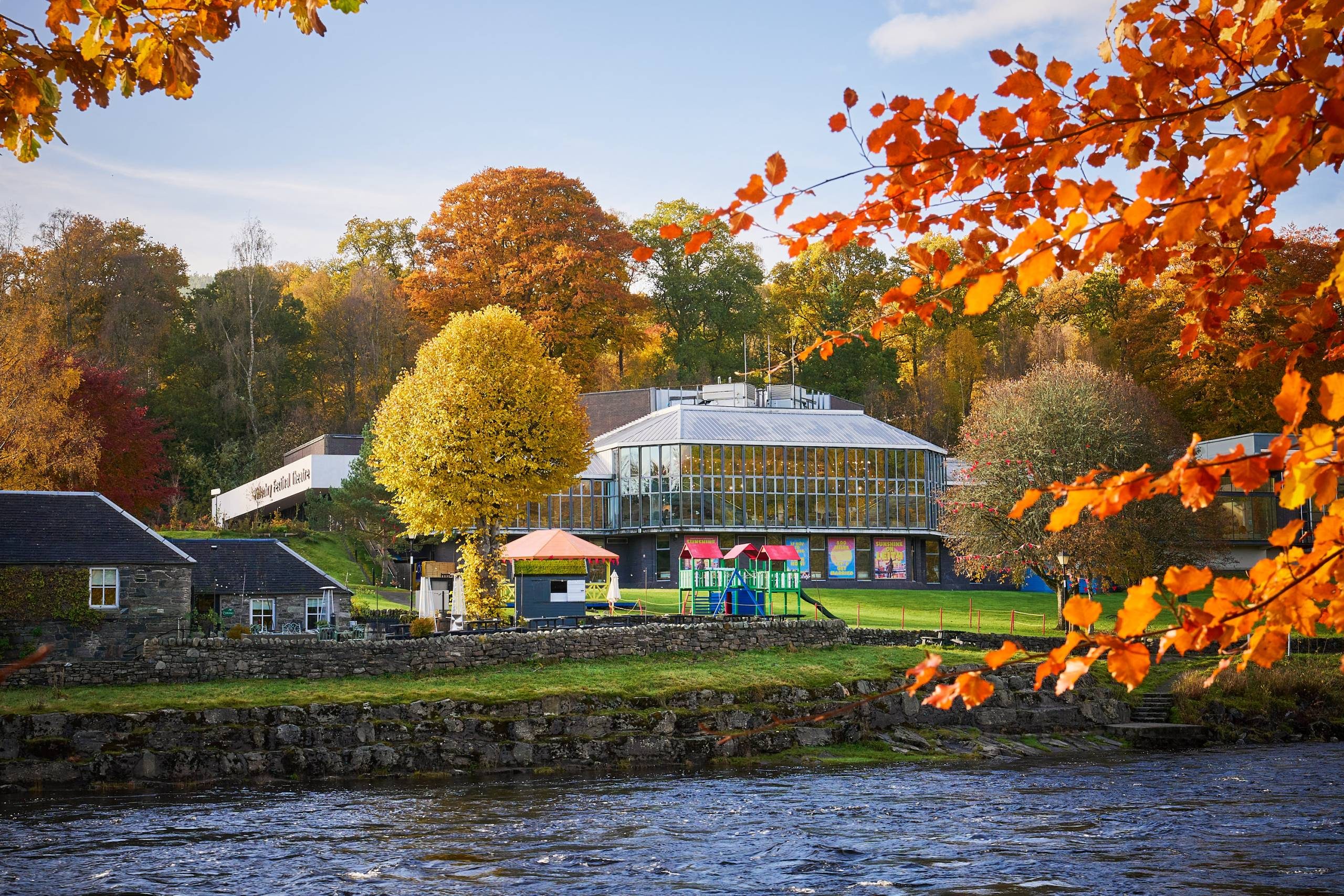 Pitlochry Festival Theatre surrounded by autumnal trees.
