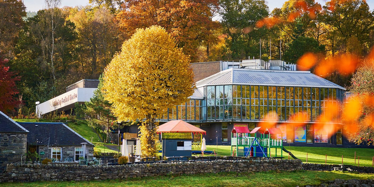 Pitlochry Festival Theatre surrounded by autumnal trees.