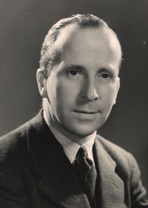 Shoulders and head of man in suit and tie.