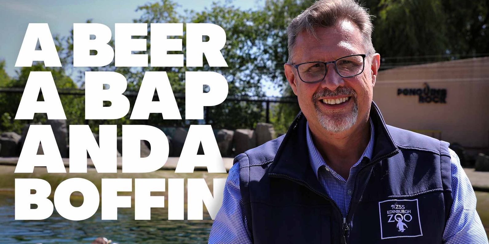 A smiling man wearing glasses and an Edinburgh Zoo vest stands by a penguin enclosure. Text reads: “A Beer A Bap And A Boffin”