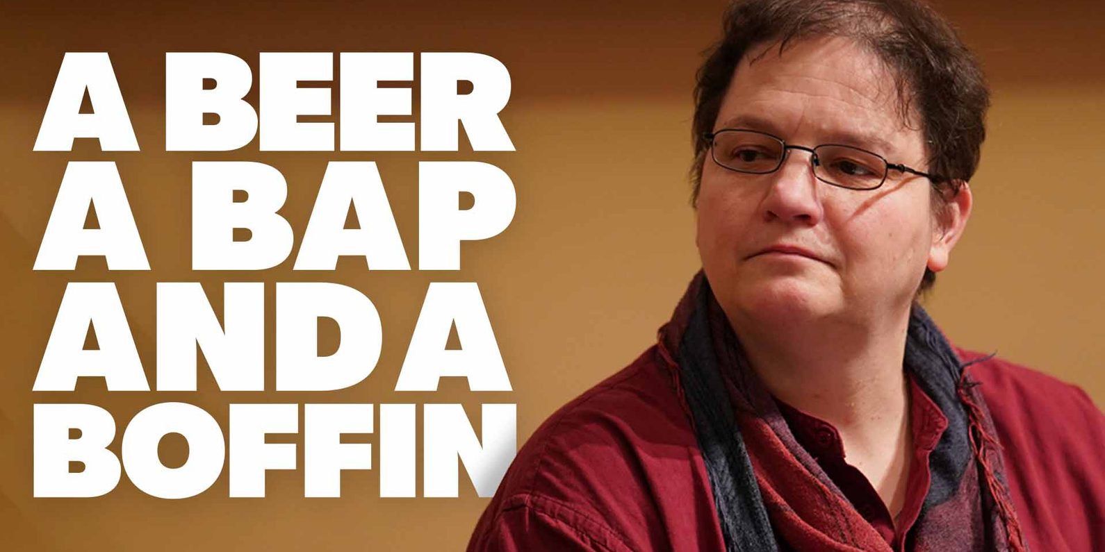 A person with short dark hair, glasses, and a red shirt looks to the side. Text reads: “A Beer A Bap And A Boffin”.