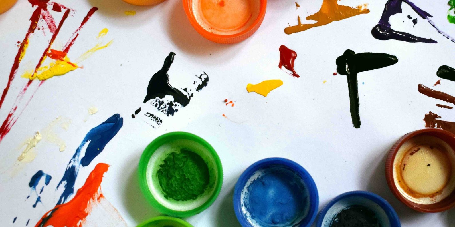 Paint pots and splashed paint on a white background