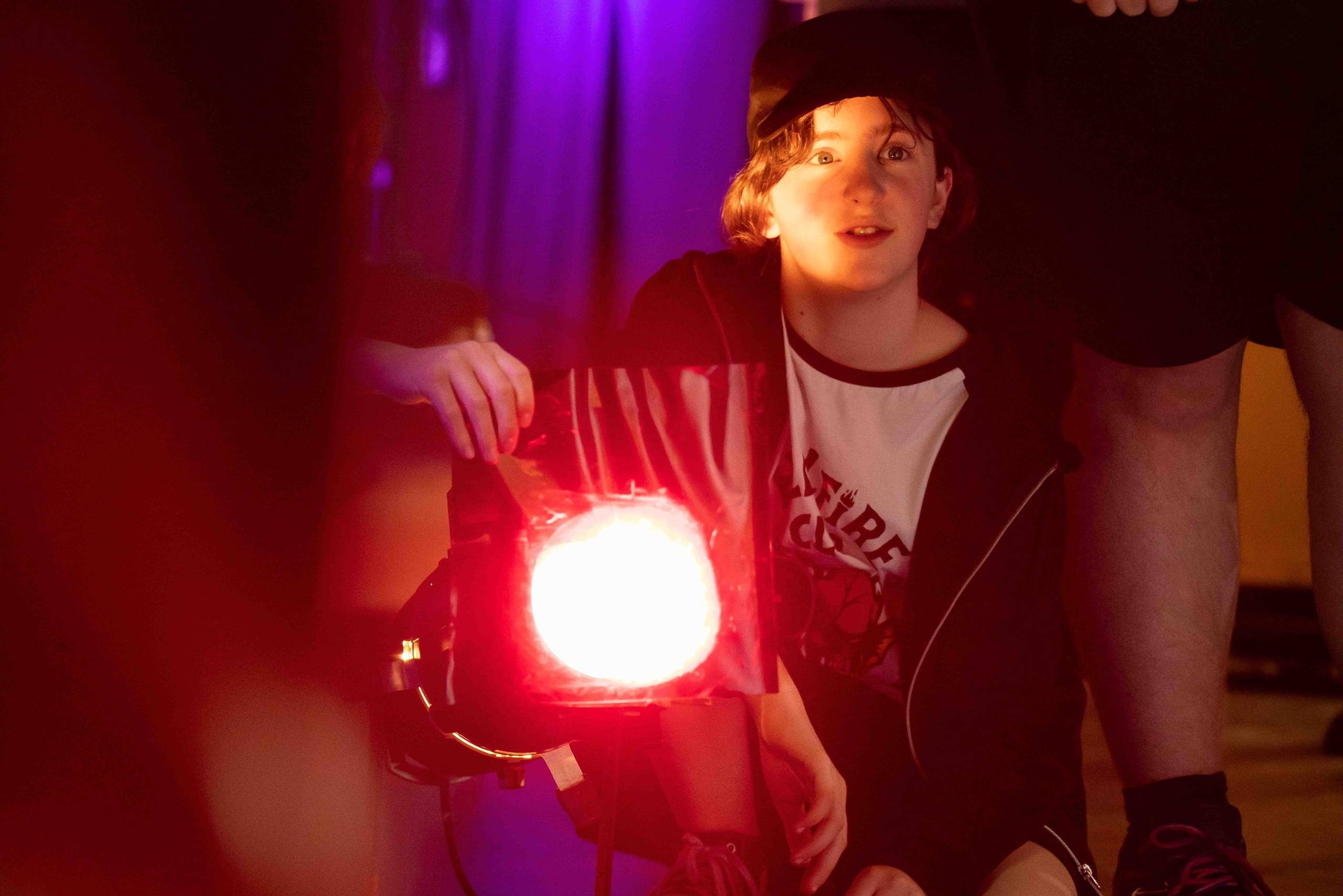 Child sitting behind a spot light