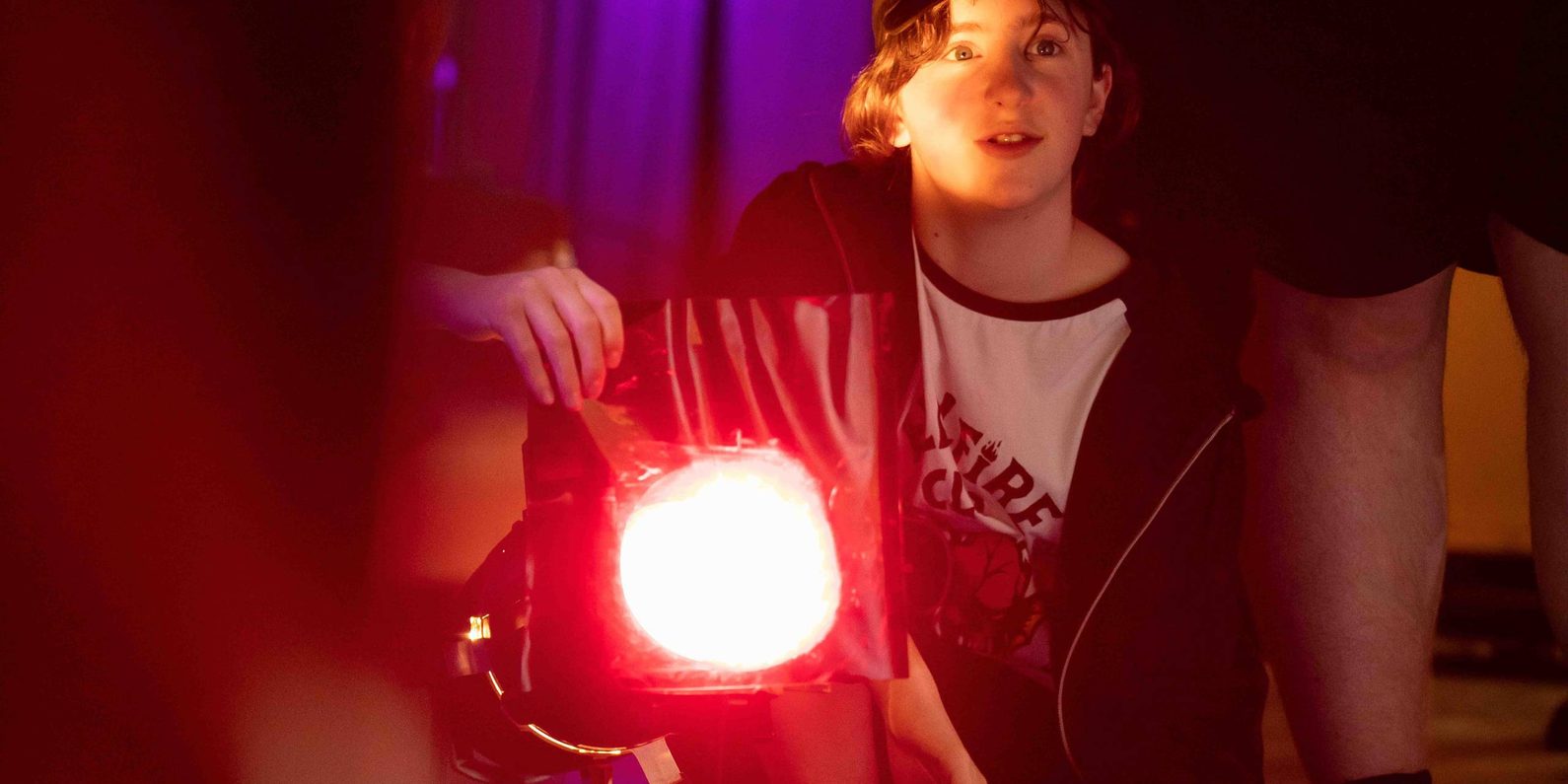Child sitting behind a spot light