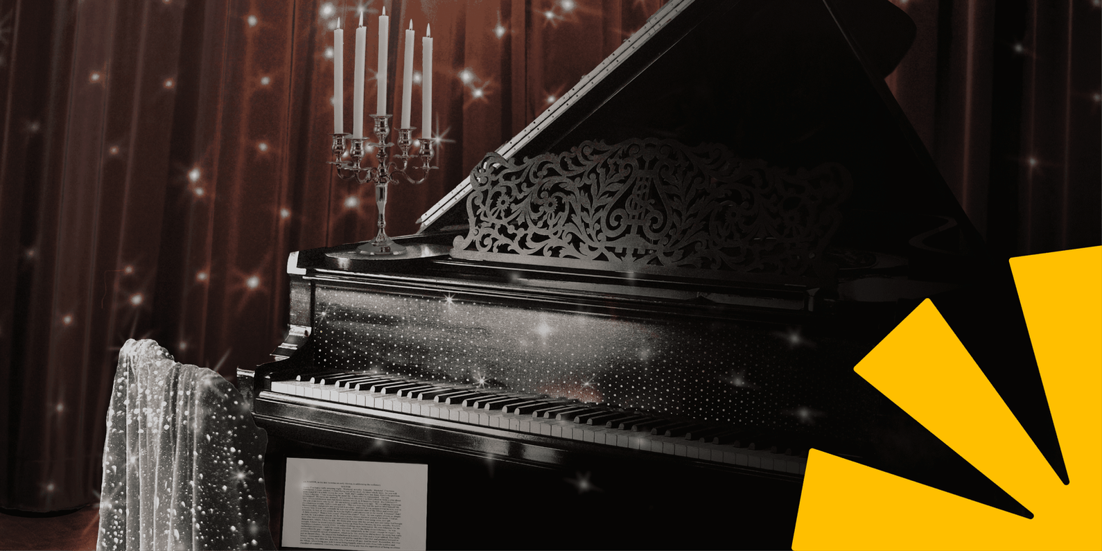 Grand piano in front of a sparkly curtain, with a sparkly jacket on the piano chair and open laptop on the piano chair